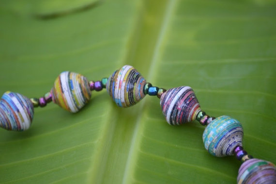 Blue toned paper bead jewelry on a green leaf background