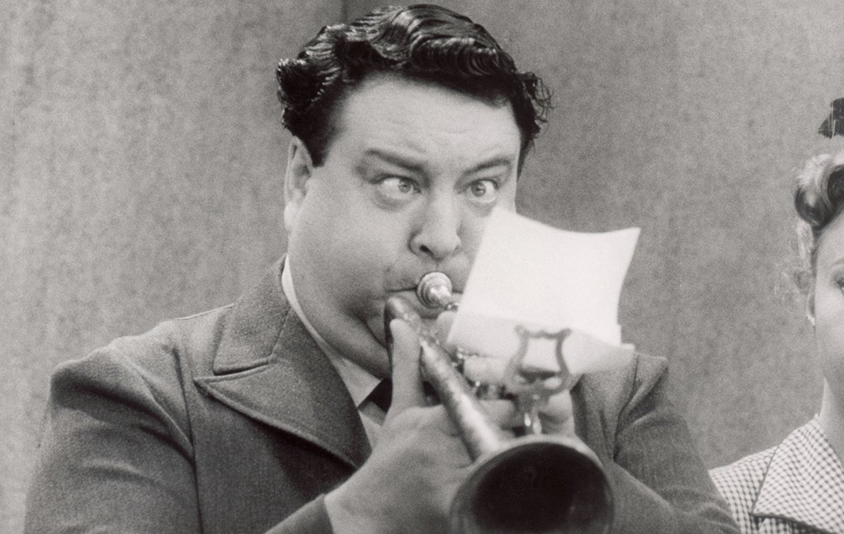 Image of Jackie Gleason blowing a trumpet