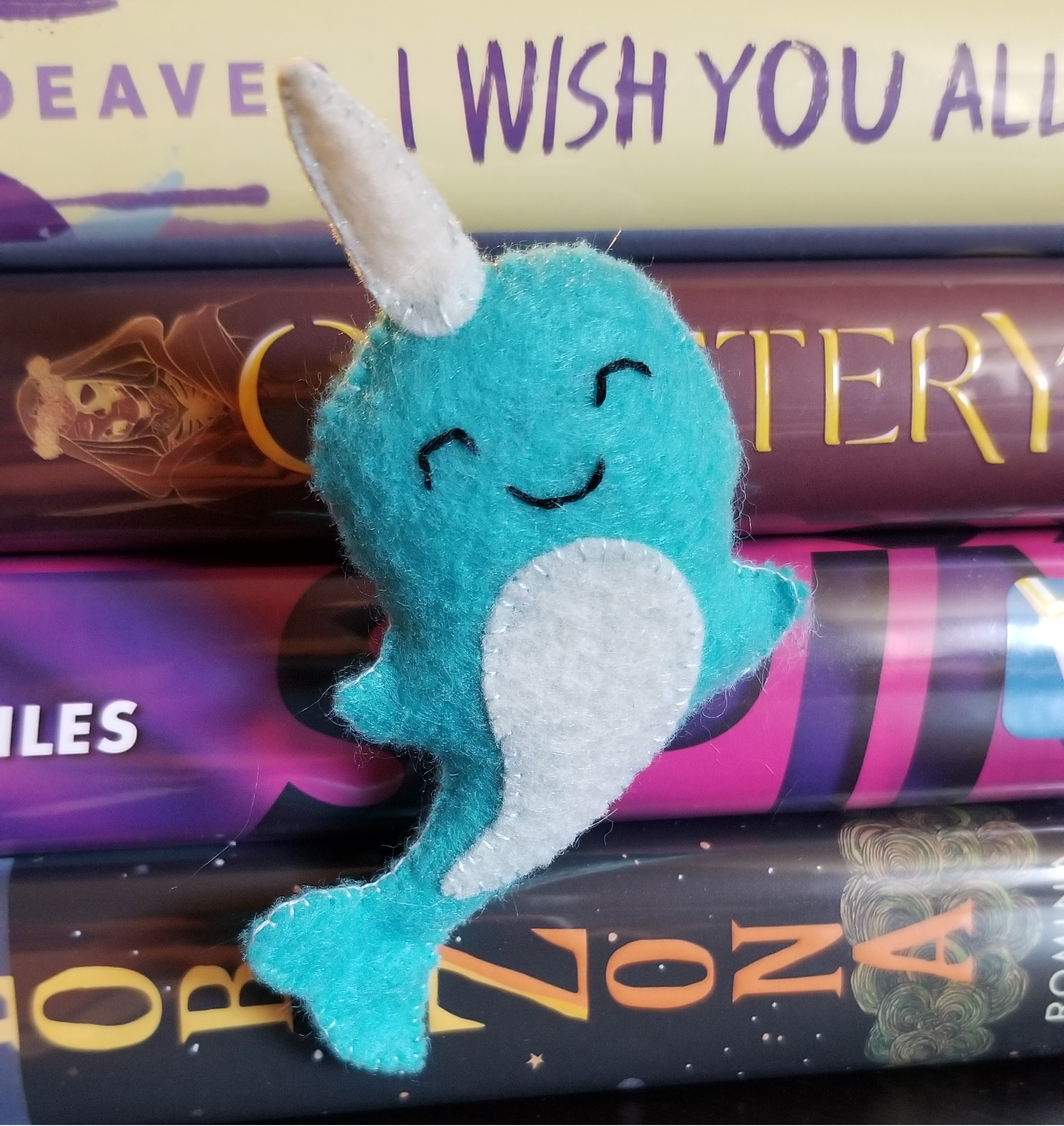 a light blue smiling narwhal plush