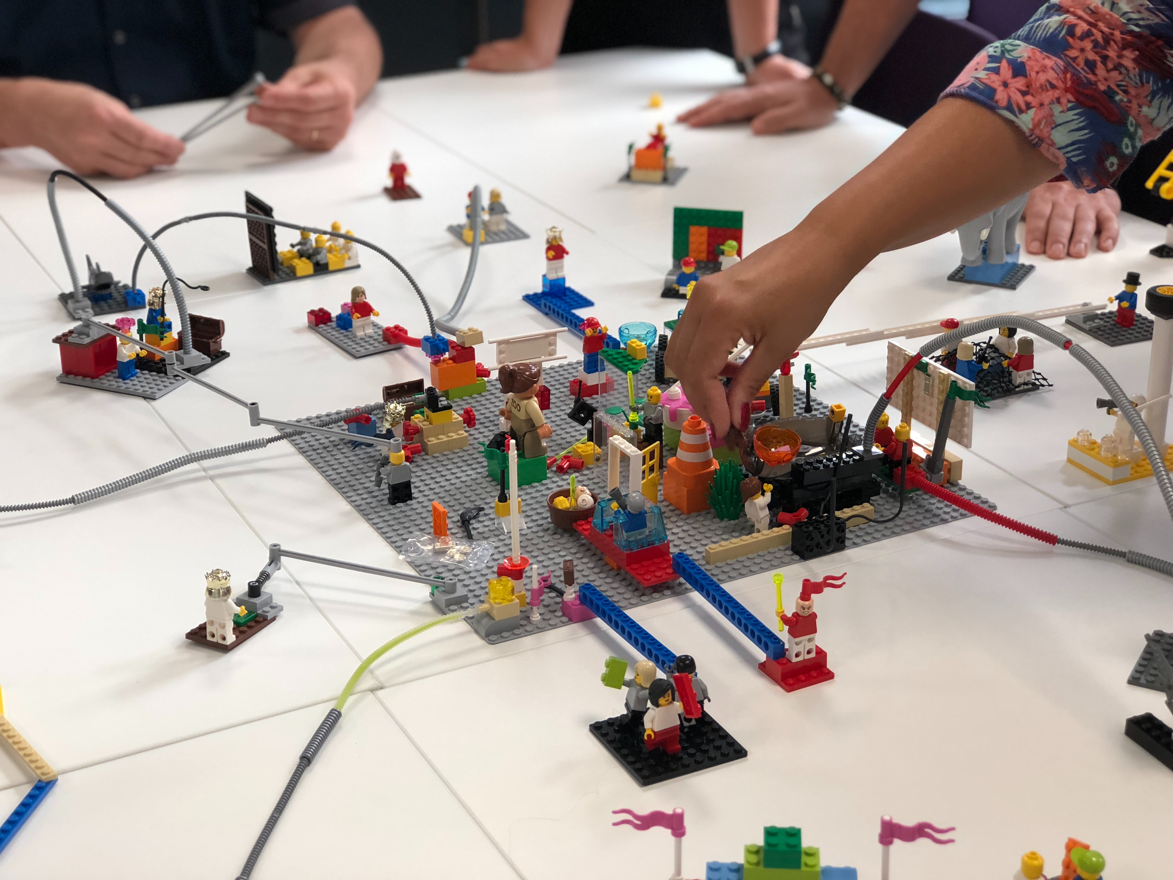 A group of children's hands are visible playing with Legos