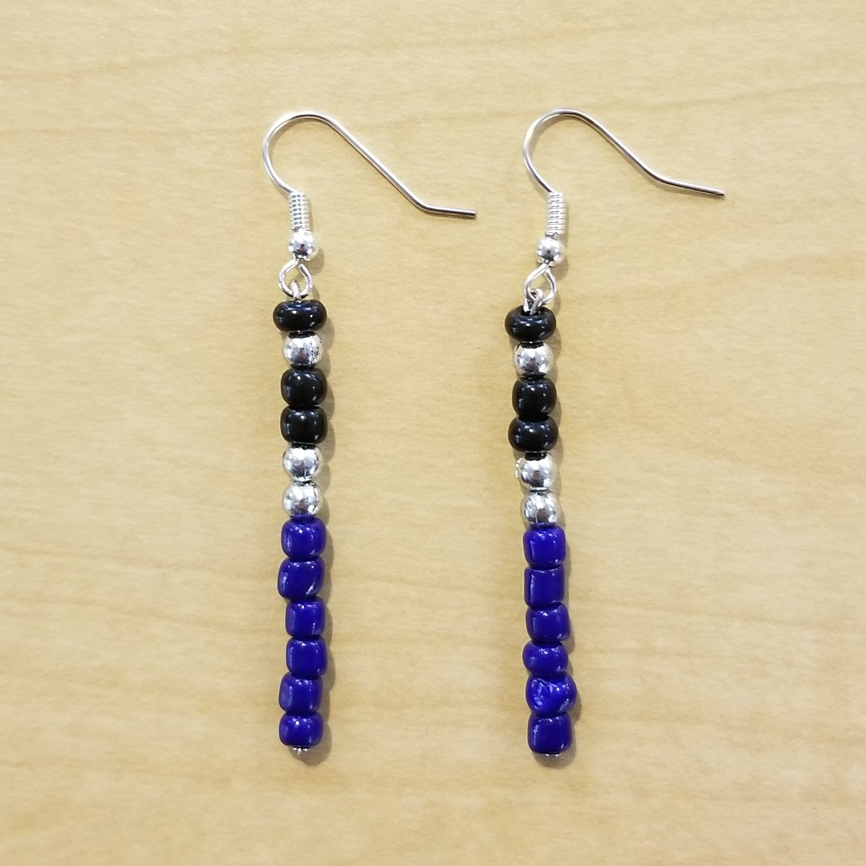 Two lightsaber earrings (blue, silver, and black beads are arranged vertically to look like a lightsaber)