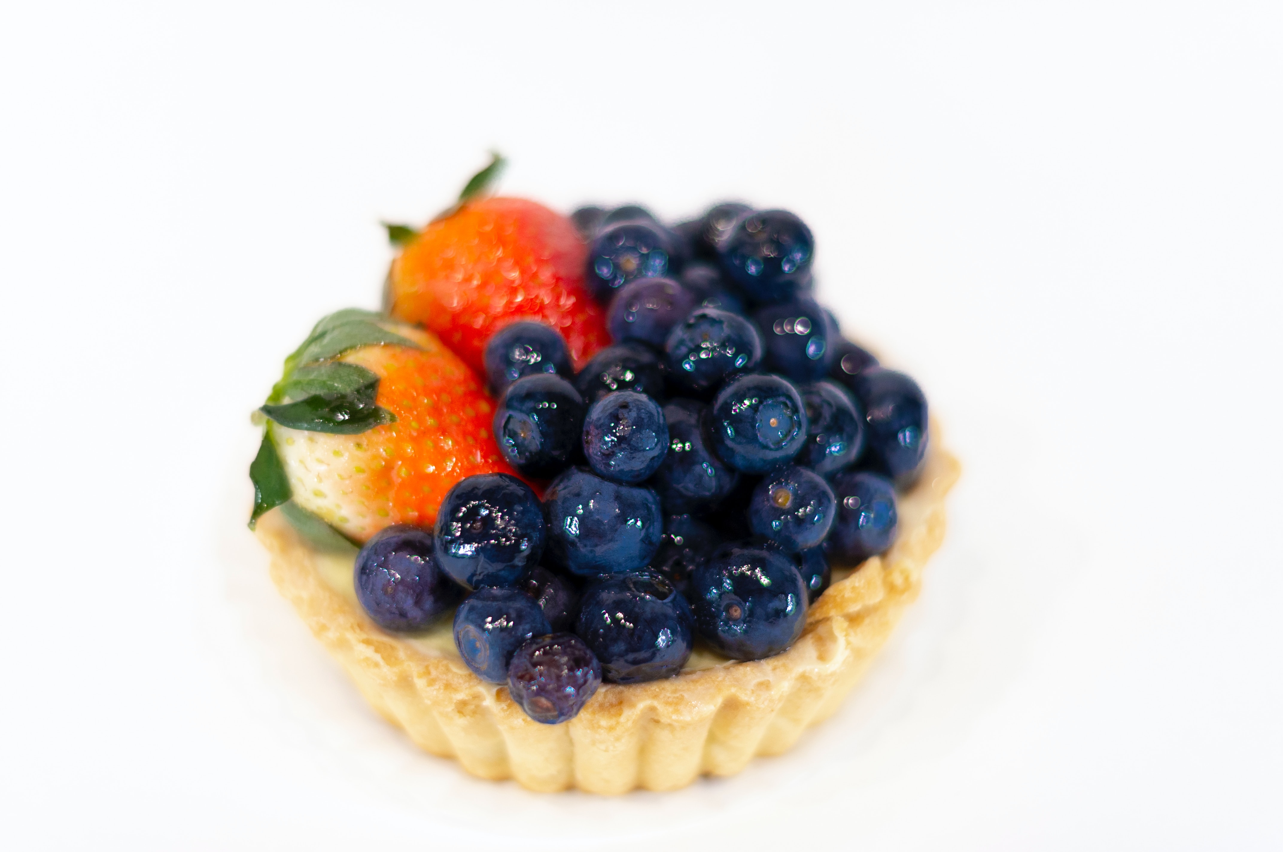 a miniature fruit tart with blueberries and strawberries