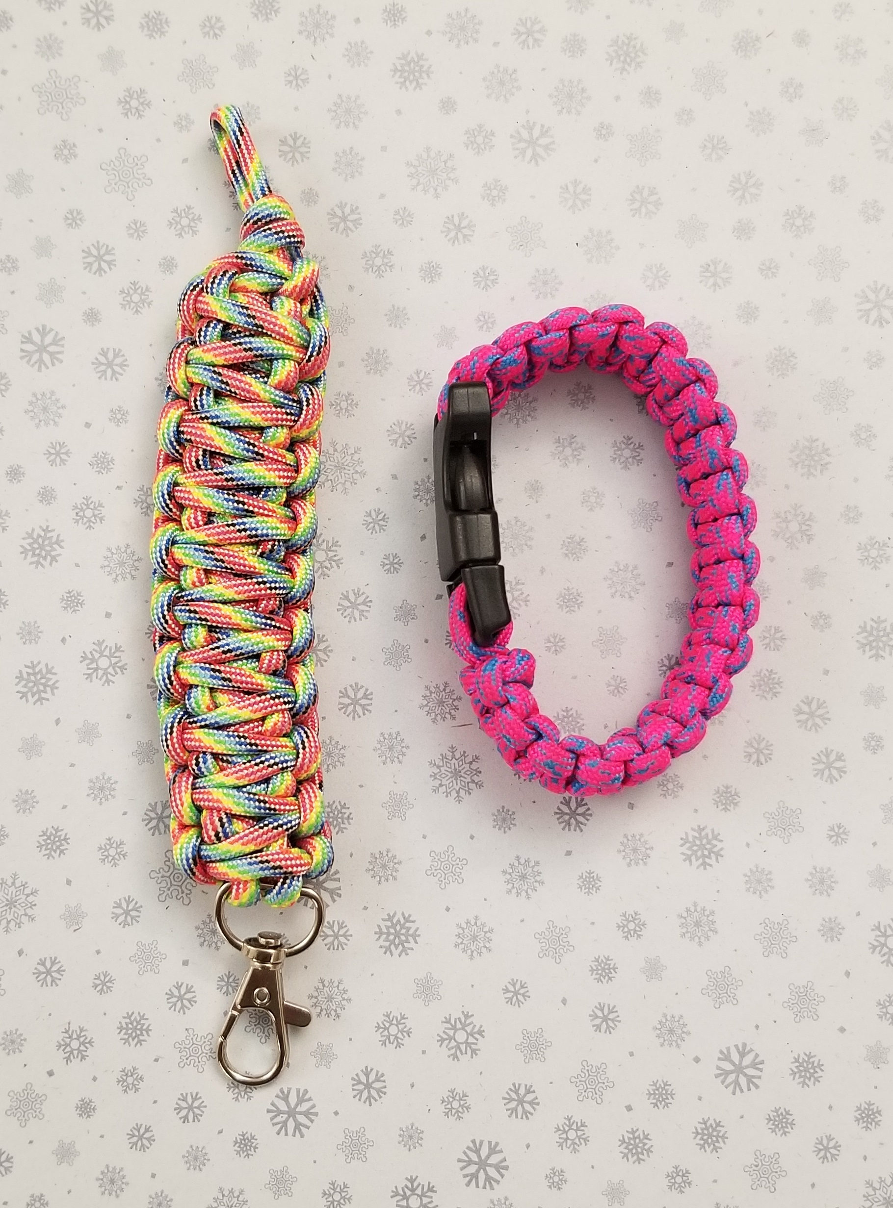 Two example paracord creations: a rainbow lanyard and pink and blue bracelet.