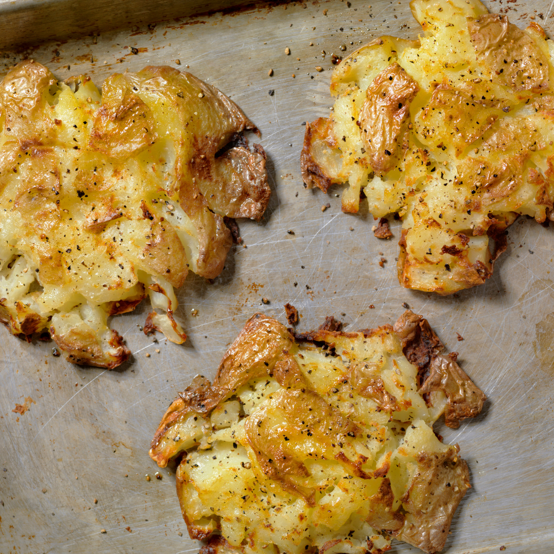 A picture of smashed potatoes (baked potatoes that have been smashed to press them down and then re-baked to make them extra crispy)