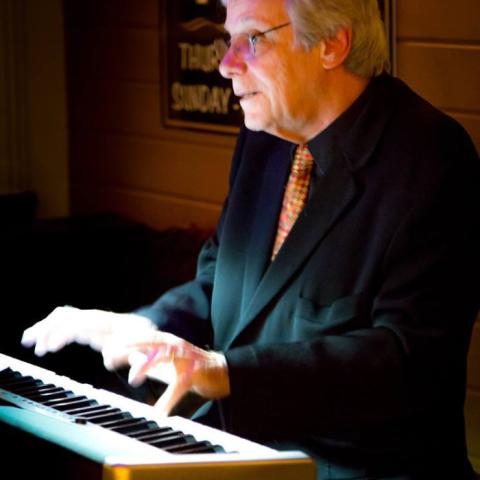 Image of John Brighenti playing a piano