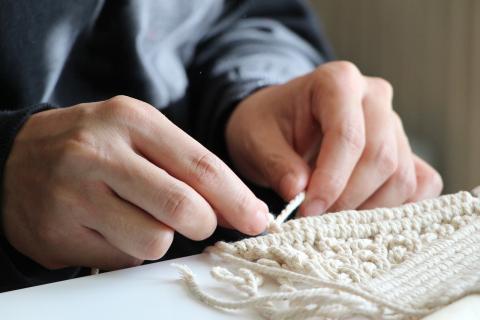 white hands tying macrame cord