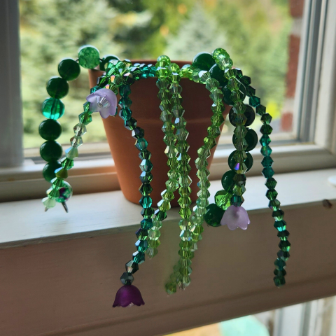 A sample of the craft: a small plant pot with strings of green beads coming out, resembling a plant.