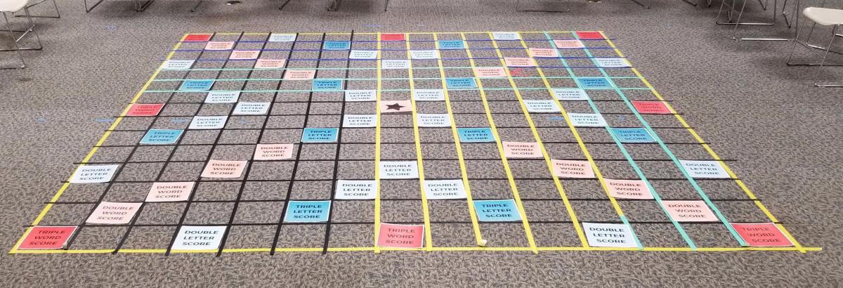 A giant scrabble board made of masking tape, empty and ready to play