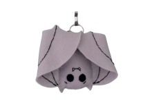 A smiling bat plush with its wings wrapped around itself